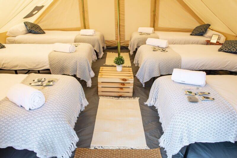 6 raised mattresses with bedding and rolled towel inside a touareg. 3 mattresses on ech side and a wooden box table in the middle